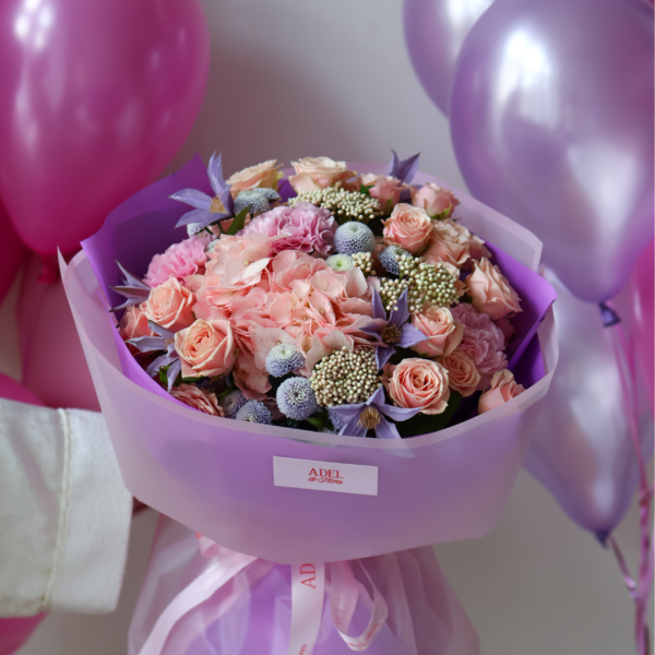 Bukiet z brzoskwiniowych róż, hortensji, klematisów i dekoracyjnych dodatków