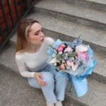 A bouquet of peonies, calla lilies and blue delphiniums