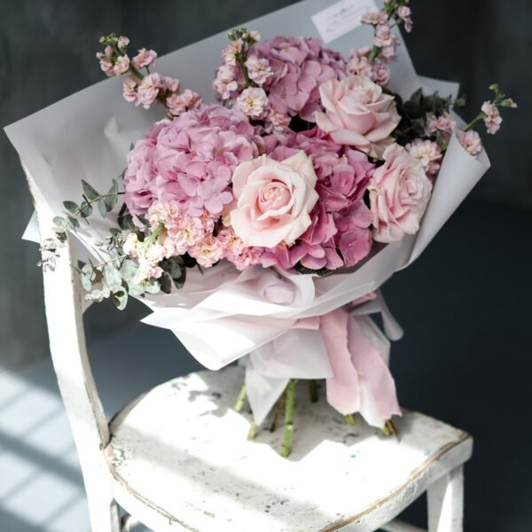A bouquet of pink hydrangeas, roses and eucalyptus