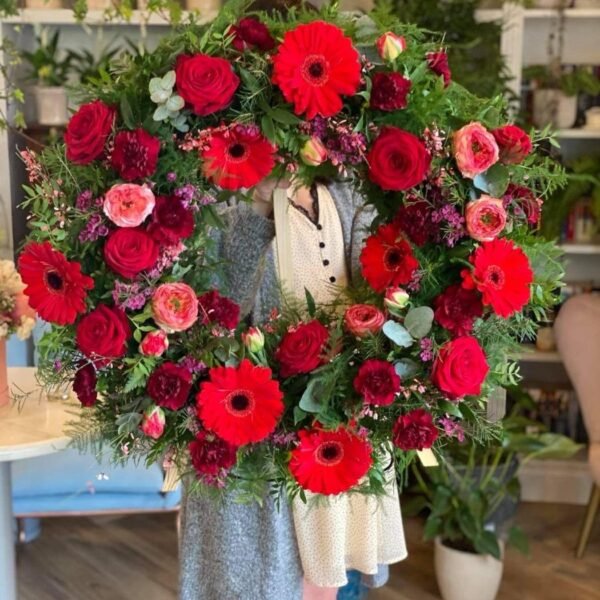A funeral wreath of red roses and gerberas — Adel de Flores